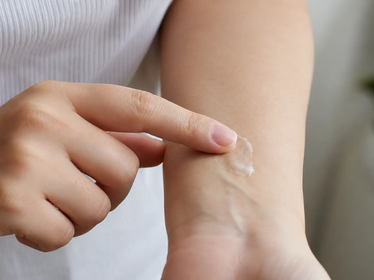 Patch testing new skincare product on inner arm before applying to face Patch testing new skincare product on inner arm before applying to face