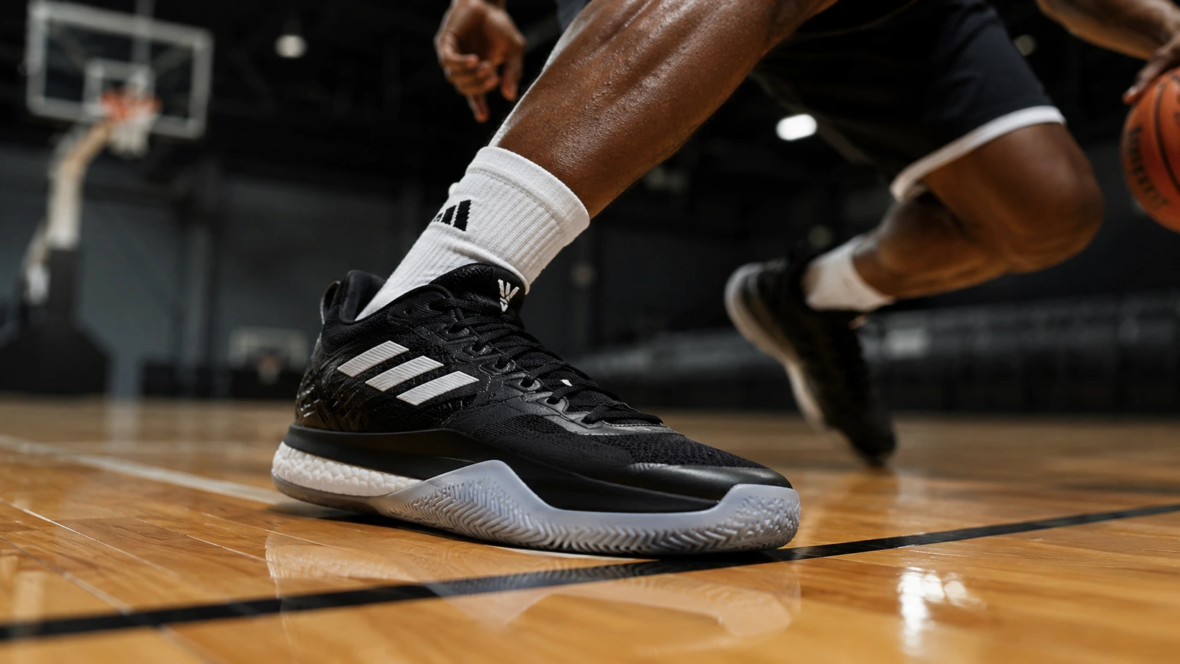 Adidas basketball shoe in action during a lateral cut on an indoor court