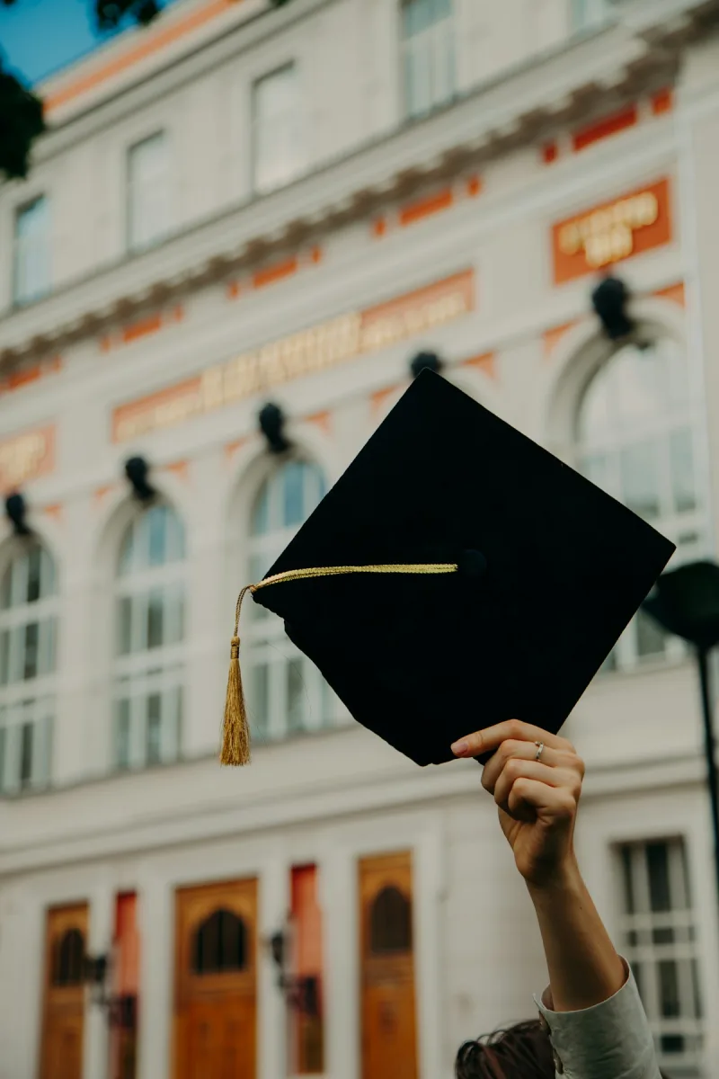 Graduate tossing cap in the air at graduation ceremony